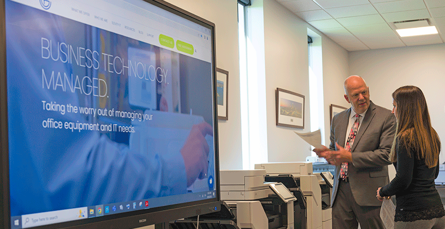 Businesspeople in a conference room with an interactive display