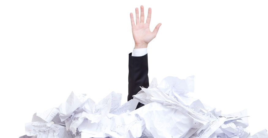 hand sticking up through a large pile of paper