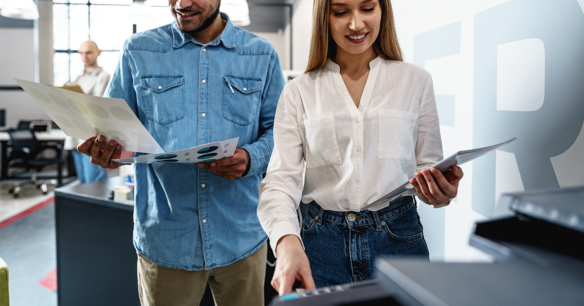 Employees learning how to use a multifunction printer