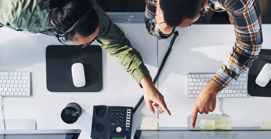 two people pointing at a computer screen